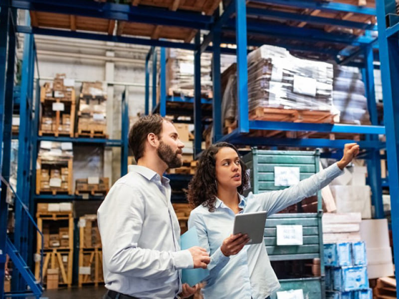 An image showing one man and one lady work together in the warehouse for reference